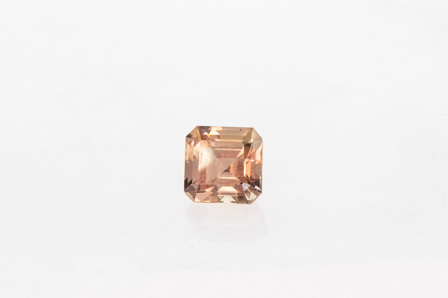 A handmade Oregon Sunstone Asscher Cut 8mm on a white background.