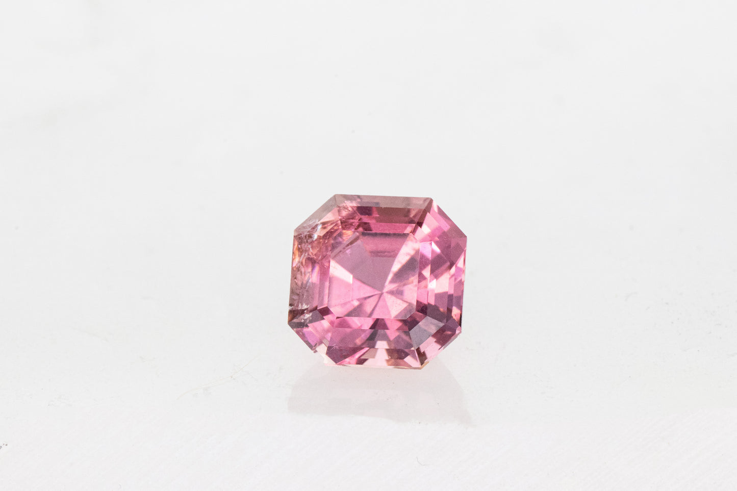 A Cassin handmade Pink Tourmaline Asscher Cut 8.2MM on a white surface.