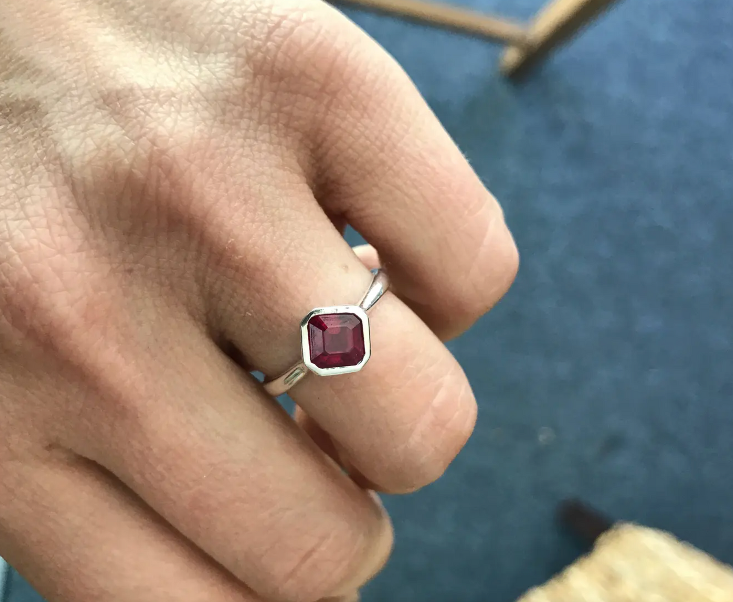 A woman wearing a handmade Asscher Cut Ruby Ring.