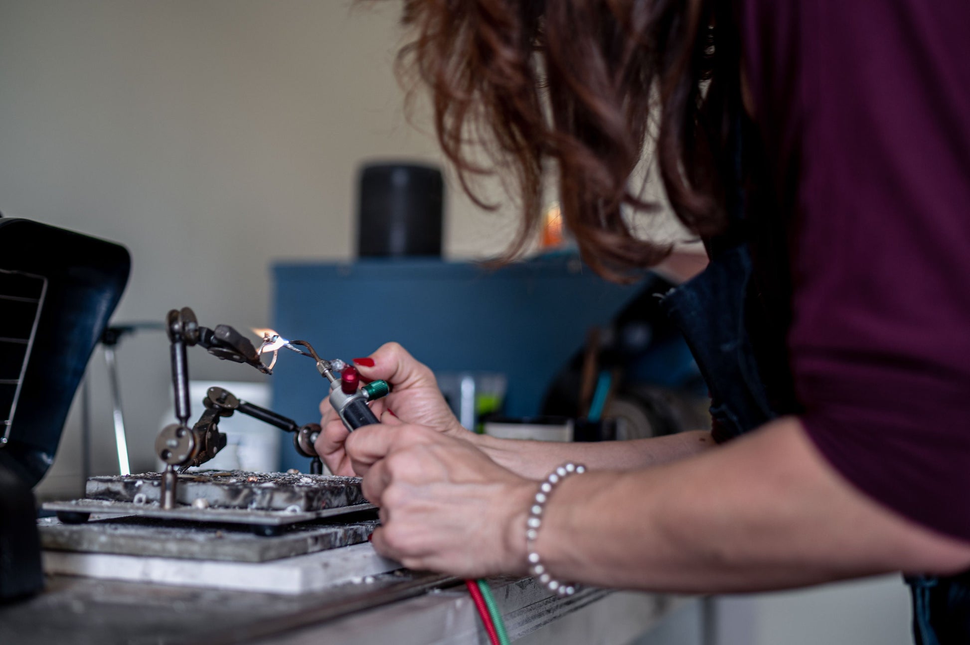 A woman is working on a handmade Round Forever One Moissanite Engagement Ring.