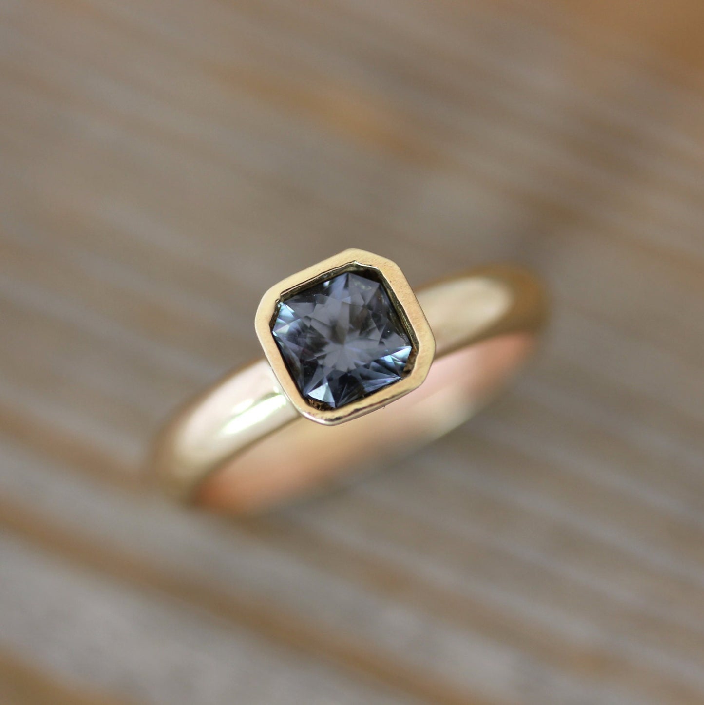 Handmade jewelry: A Asscher Cut Pink Spinel Ring in 14k Yellow Gold with a blue sapphire in the center.