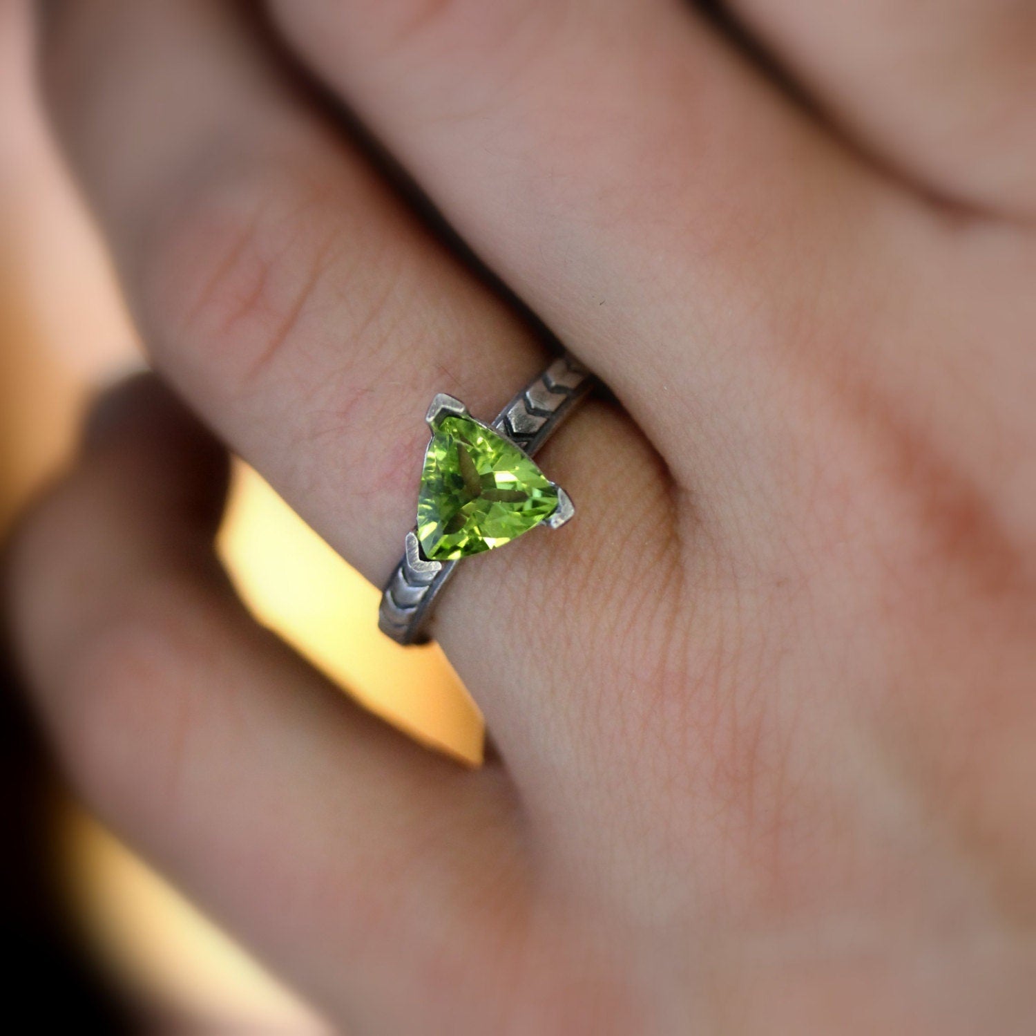 A woman's hand holding a Peridot Gemstone Ring in Sterling Silver, showcasing handmade jewelry by Cassin Jewelry.