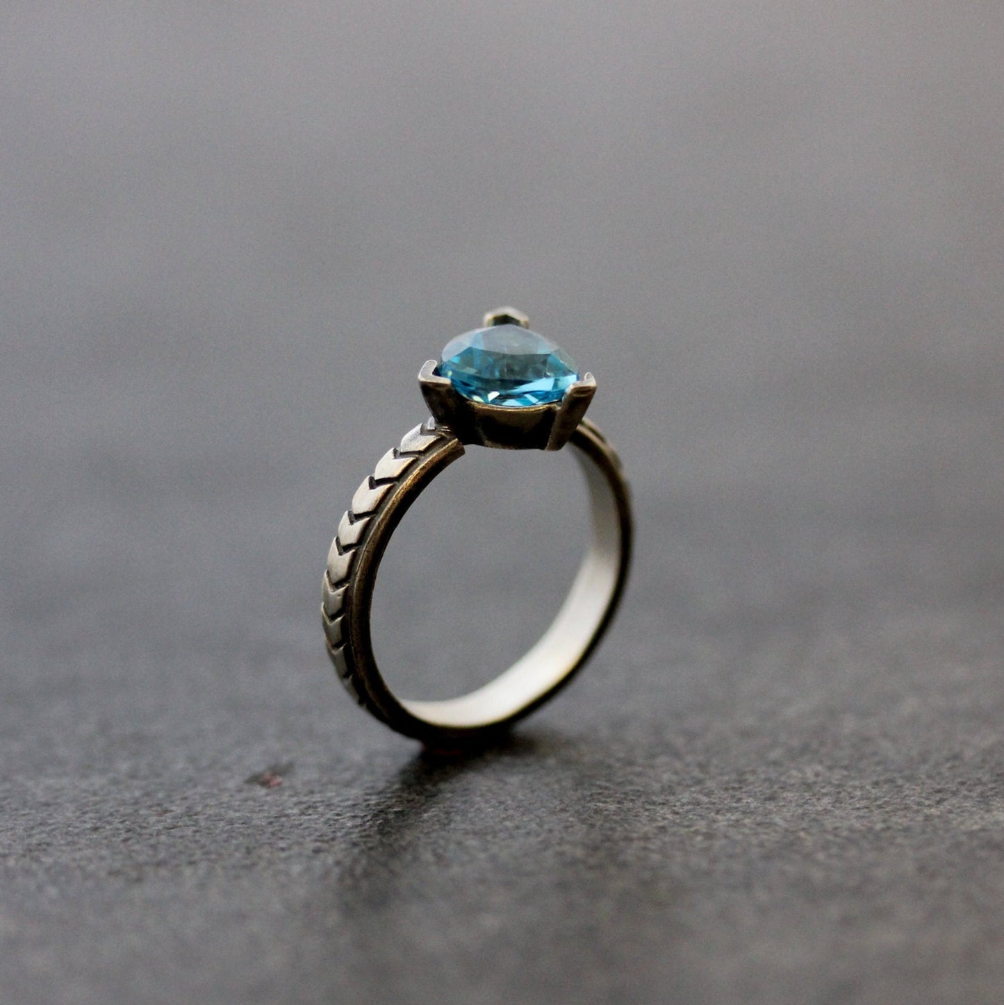 A handmade Peridot Gemstone Ring in Sterling Silver by Cassin Jewelry featuring a blue topaz stone.