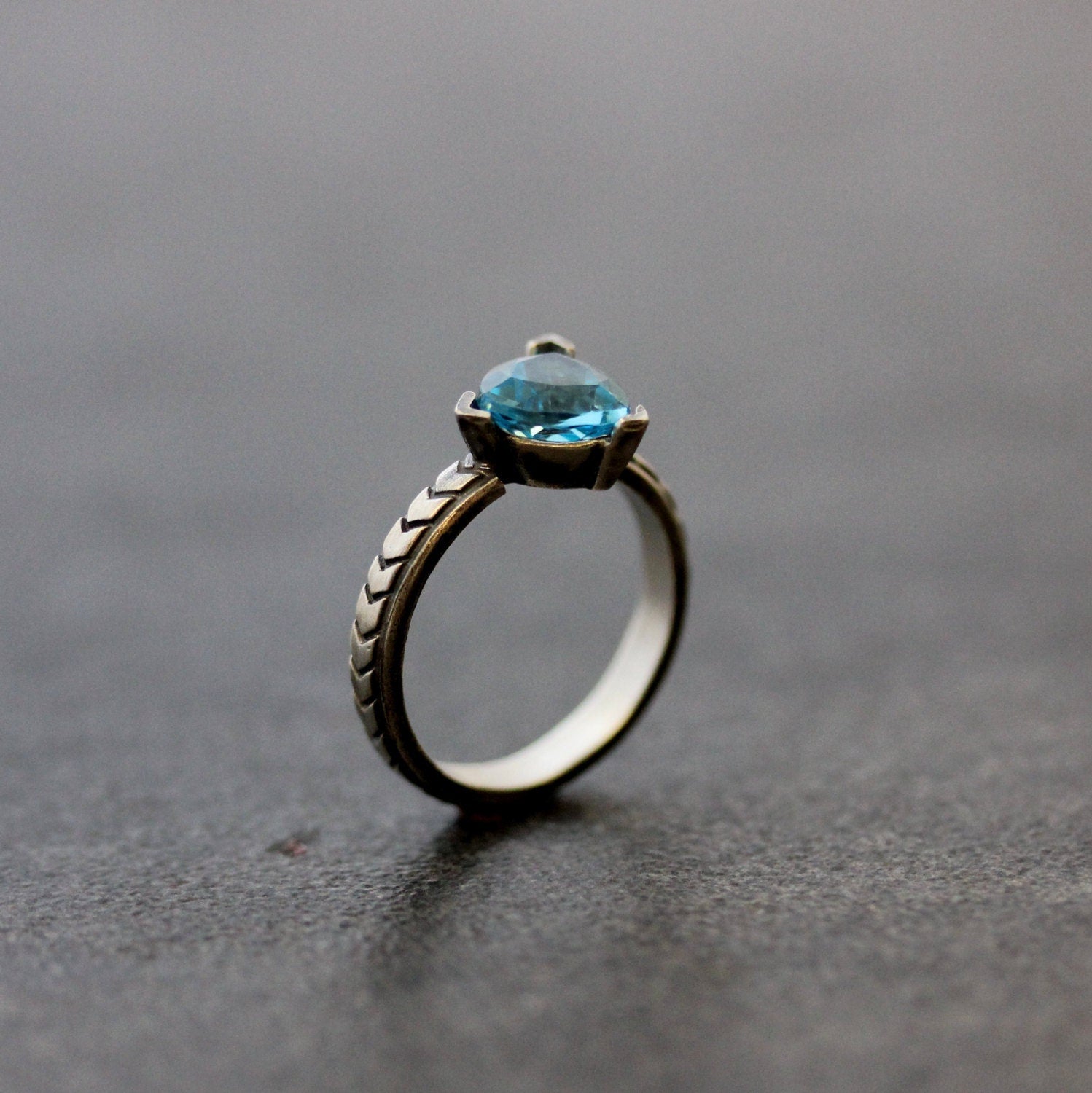 A handmade Peridot Gemstone Ring in Sterling Silver by Cassin Jewelry featuring a blue topaz stone.