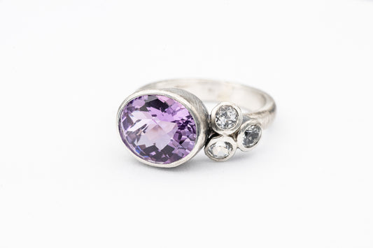 A Rose De France Amethyst and diamond ring on a white background.