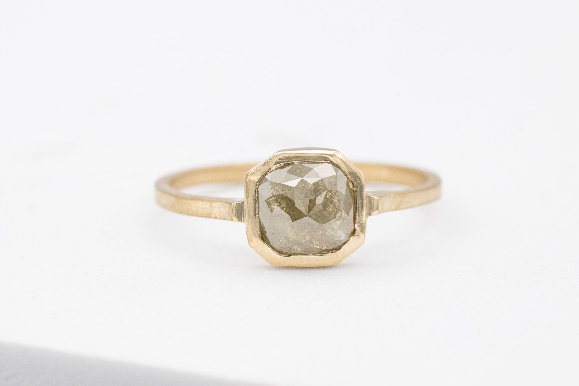 A handmade Gray Diamond Ring in 14k Yellow Gold with an oval shaped diamond.