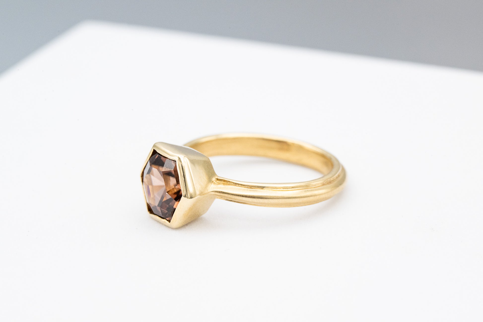 A handmade Tawny Champagne Yellow Gold Hexagon Ring with a smoky quartz stone.