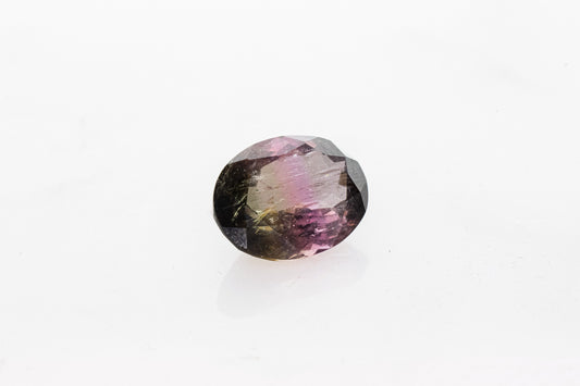 A Tricolor Tourmaline Oval 11x15MM gemstone on a white surface, handmade jewelry.