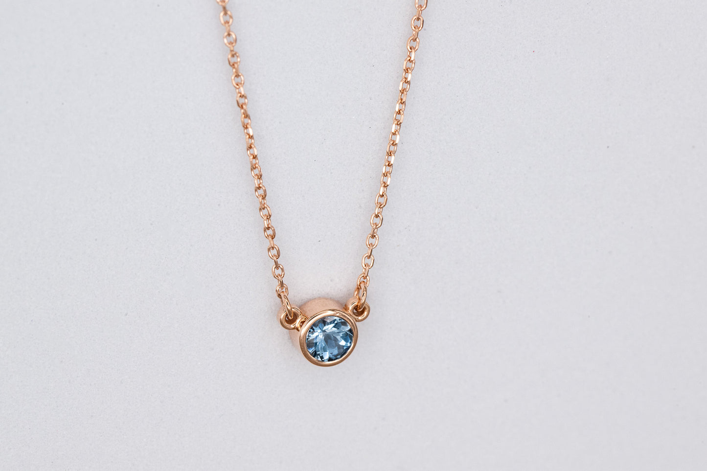 A Cassin handmade Aquamarine Rose Gold Necklace with a blue topaz stone.