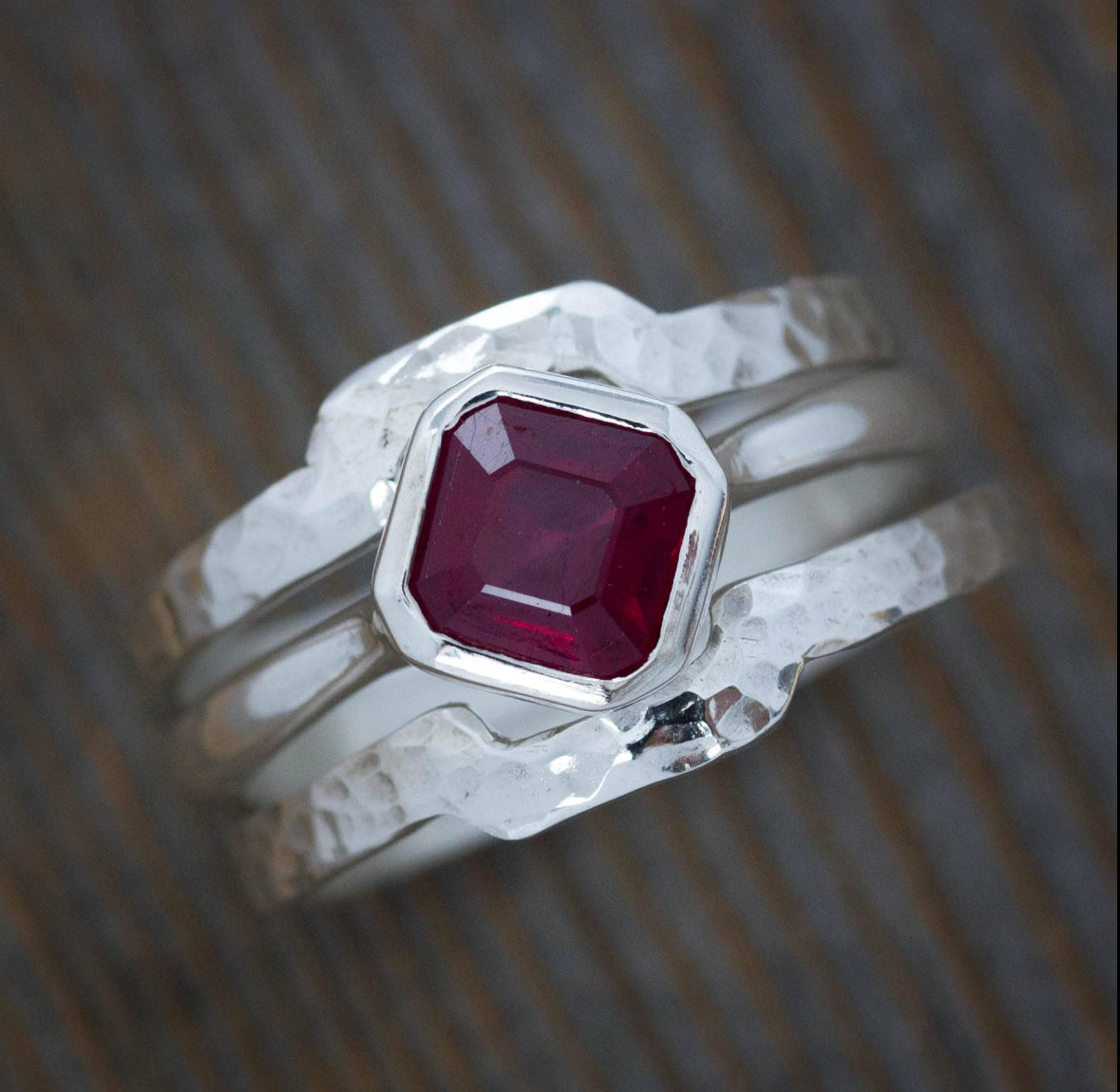 Introducing the "Set of Hammered Wrap Bands" in sterling silver, showcasing a striking rectangular red gemstone at its center. This ring features wrap-style bands with an elegant hammered texture.