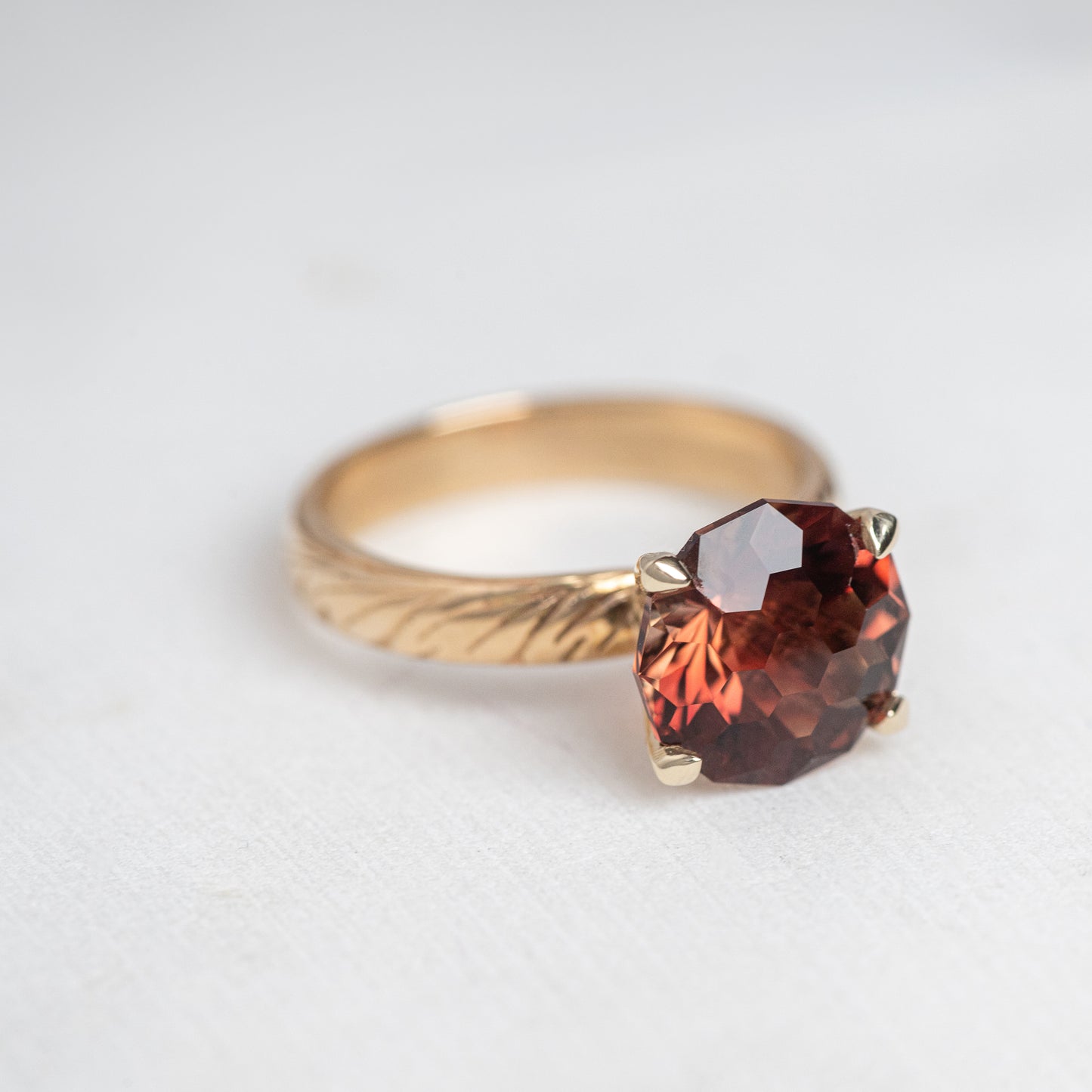 A One of A Kind Custom Handcrafted Oregon Sunstone Ring in 14k Yellow Gold Size 7 featuring a large, faceted, dark red gemstone set in a four-prong setting.