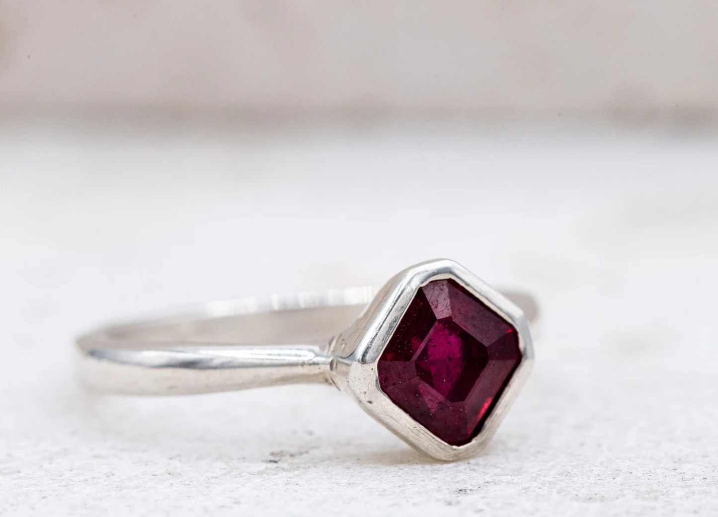 A Handmade Asscher Cut Ruby Ring in Sterling Silver with a ruby stone in the middle.