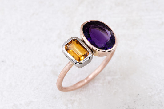 An Asymmetrical Amethyst and Citrine Ring handmade jewelry on a white surface.