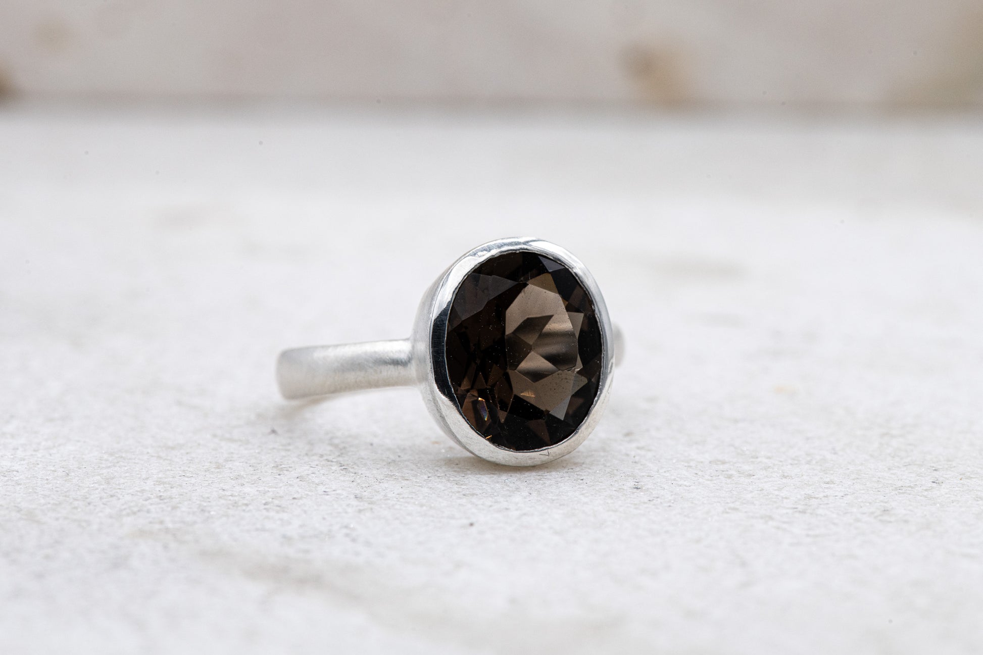 A handmade Solitaire Smoky Quartz Ring with a dark brown stone by Cassin Jewelry.