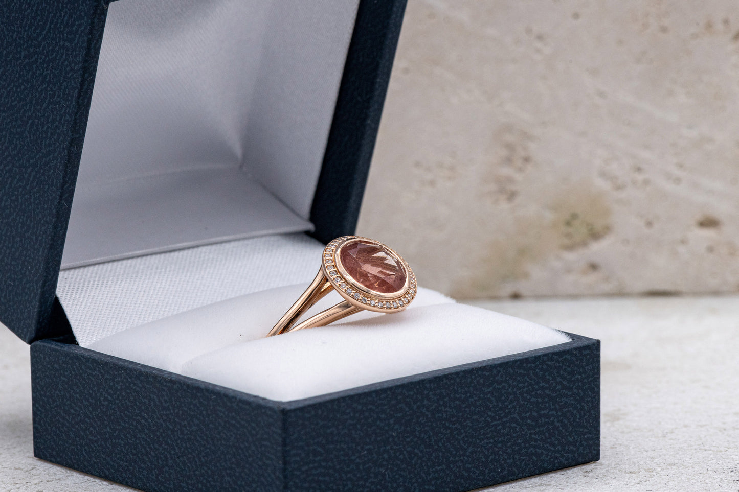 A handmade Oregon Sunstone Diamond Halo Ring in a box.