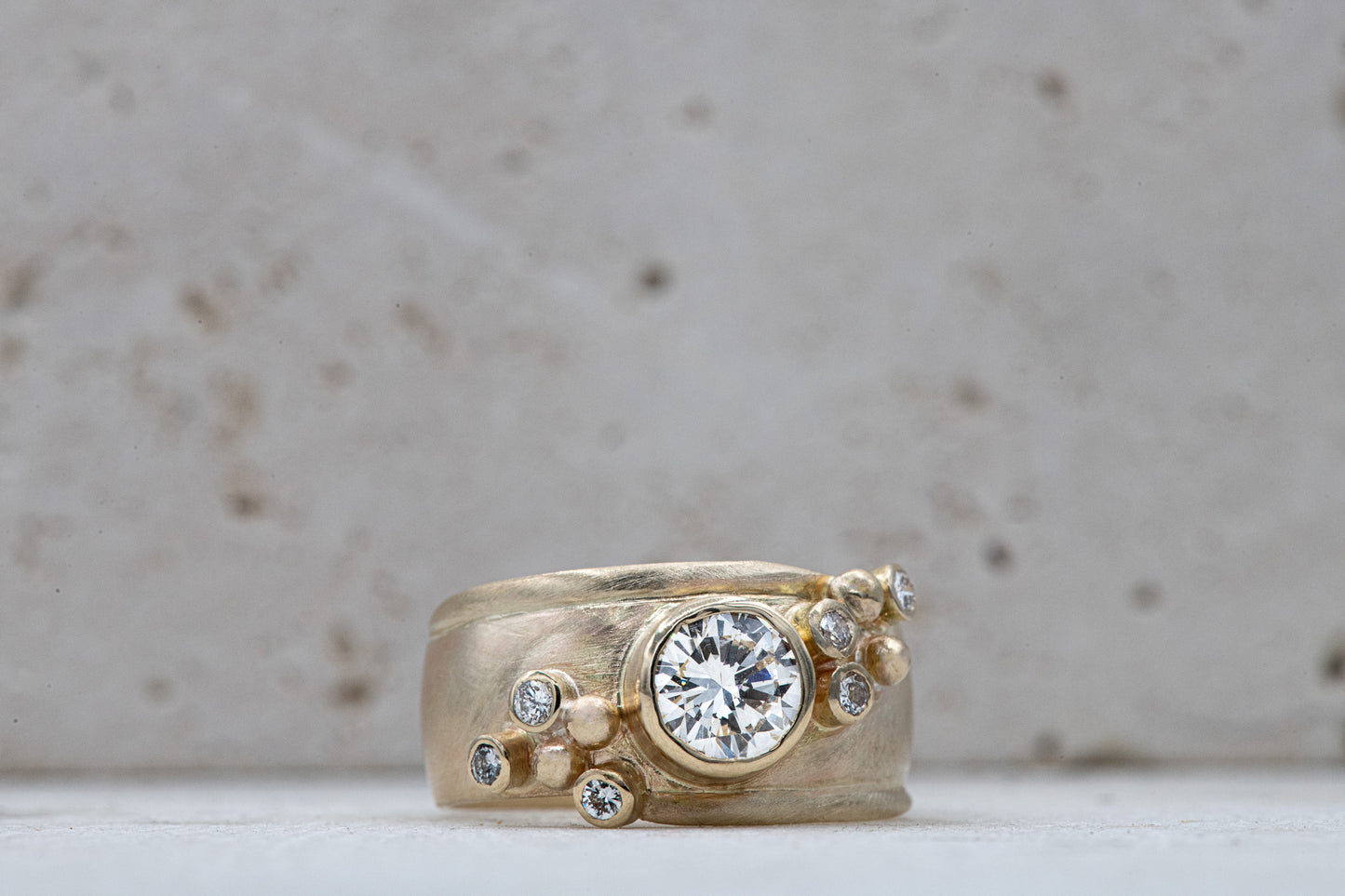 Handmade jewelry: A Wide Forever One Moissanite Gold Ring with a diamond in the center.