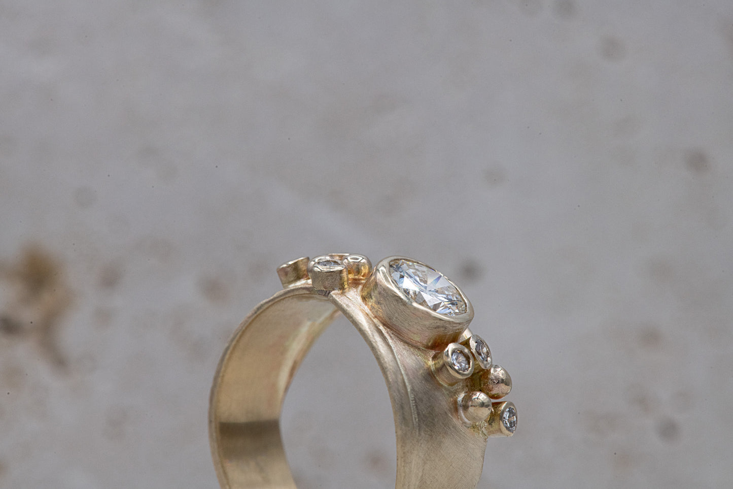 A Wide Forever One Moissanite Gold Ring with a diamond in the center, handmade by Cassin Jewelry.
