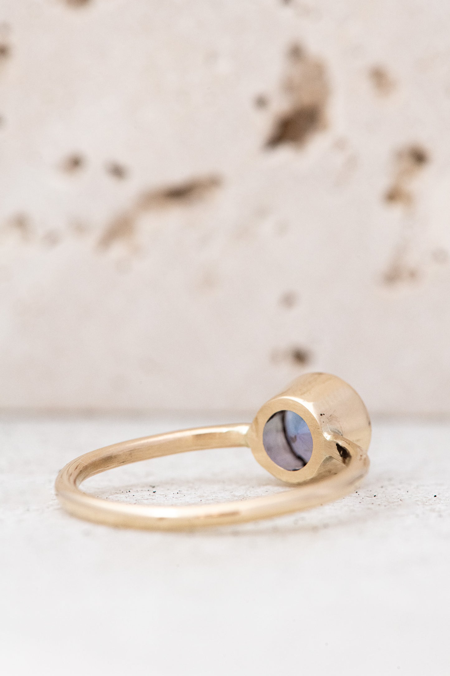 A Handmade Round Tanzanite Solitaire Ring with an abalone stone.