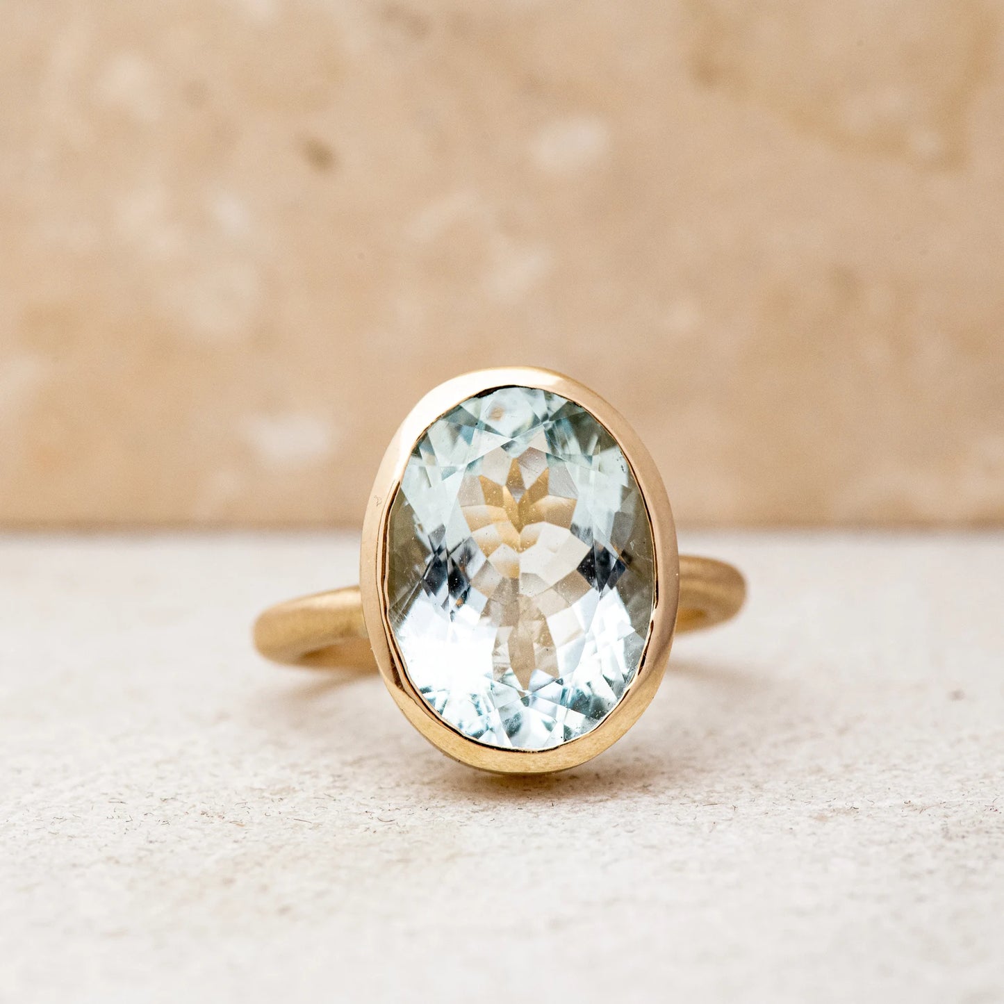 A handmade cassin jewelry piece featuring a large oval aquamarine stone set in yellow gold.
