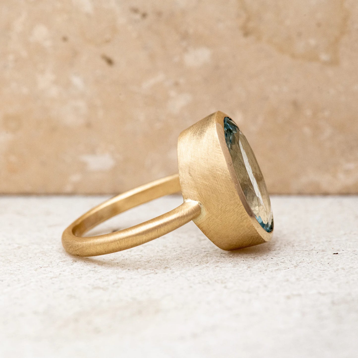 A Large Oval Aquamarine Ring in Yellow Gold with a blue topaz stone, handmade by Cassin Jewelry.