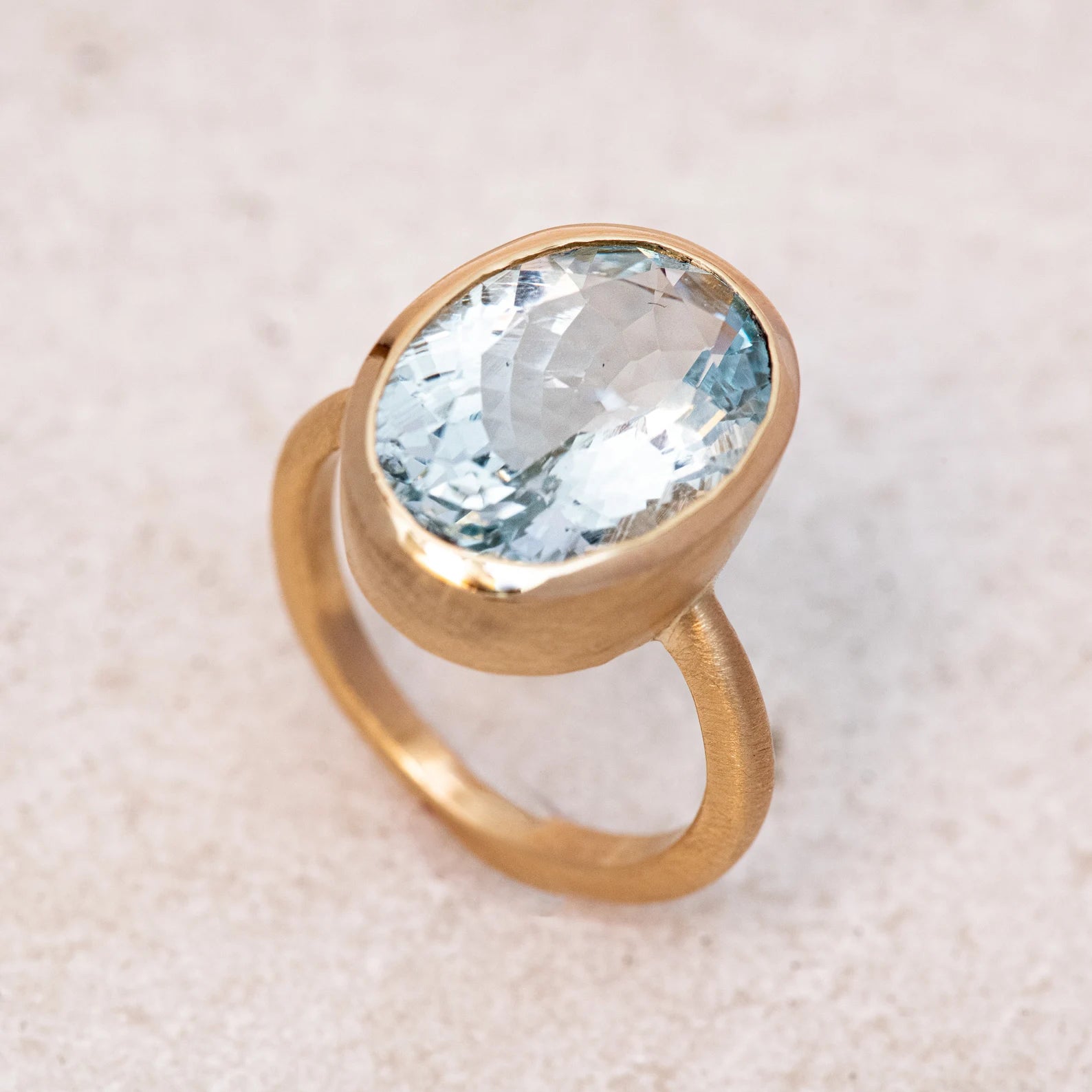 A Large Oval Aquamarine Ring in Yellow Gold with an aquamarine stone, handmade by Cassin Jewelry.