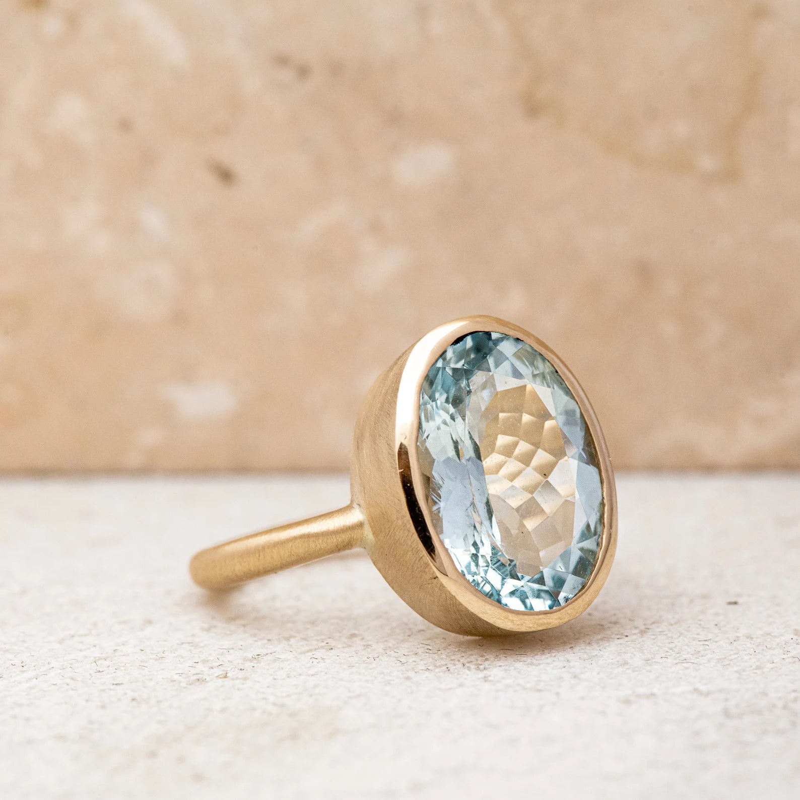 A Large Oval Aquamarine Ring in Yellow Gold with a blue topaz stone, handmade by Cassin Jewelry.