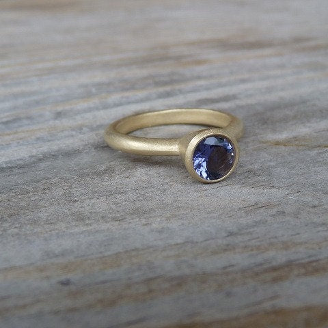 A Blue Iolite and Yellow Gold Handmade Ring with a blue sapphire stone.