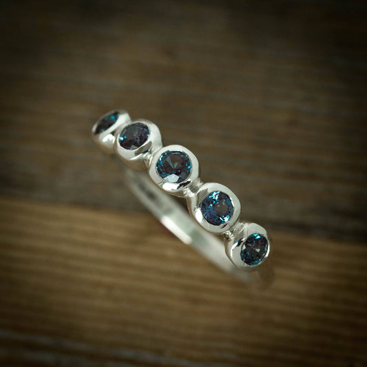 A handmade Alexandrite Five Stone Ring with blue topaz stones.