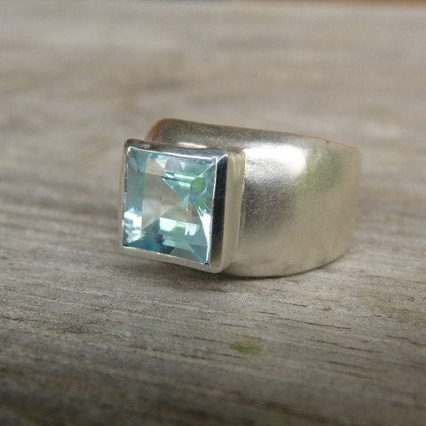 A handmade Sterling Silver Square Princess Cut Ring with a blue topaz stone.
