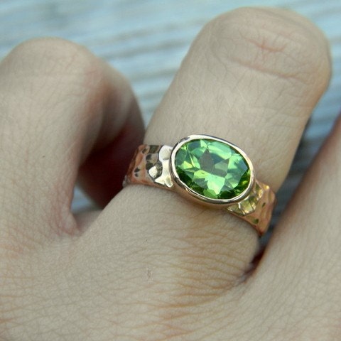 A person wearing a handmade Peridot Ring in Rose Gold.