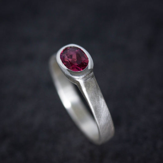 A handmade Pink Tourmaline Wide Band Ring, Brushed Silver With Low Profile, Size 7 Oval Gemstone Solitaire and October Birthstone with a ruby stone by Cassin Jewelry.