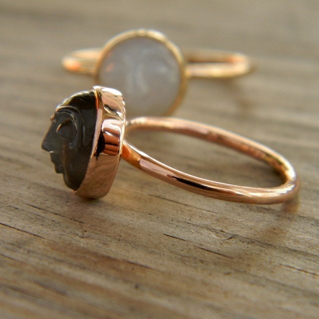 A Handmade Rose Gold Moonstone Ring with a white stone and a black stone.