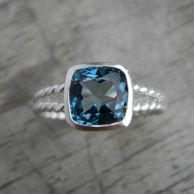 A handmade Cassin jewelry piece featuring a Silver London Blue Topaz Split Shank Ring with a beautiful blue topaz stone.