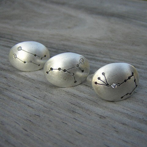 Three handmade silver cufflinks with Scorpio Constellation Rings on them.