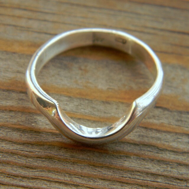 Handmade Wrap Band Wedding Band in Argentium Silver displayed on a wooden table.