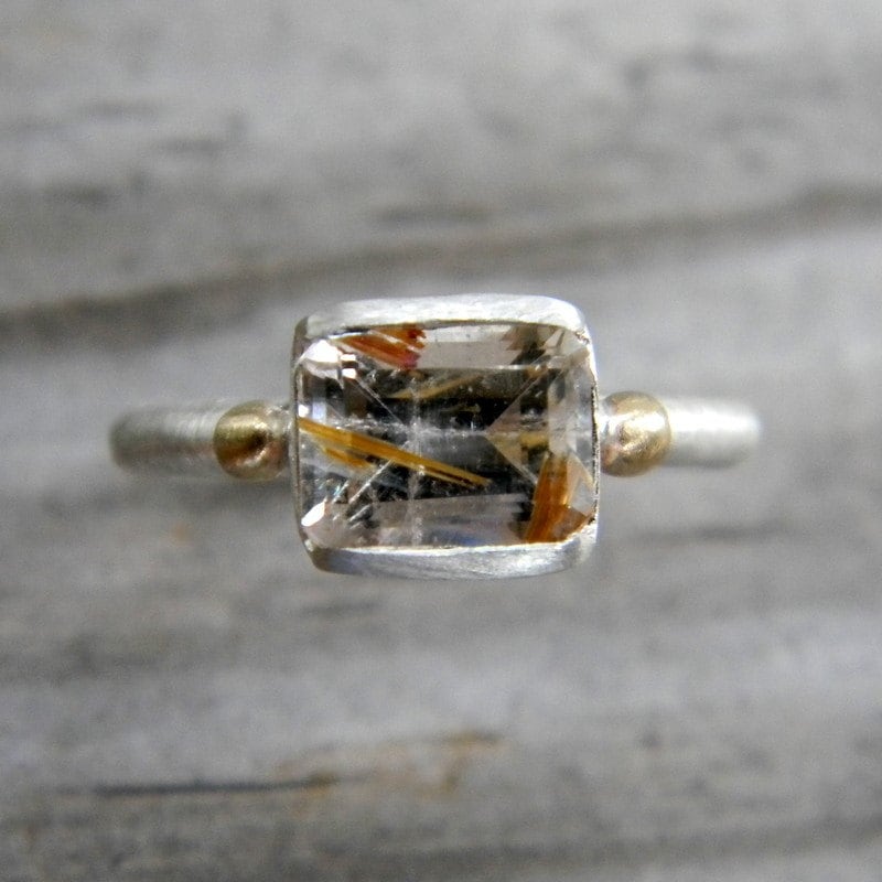 A Handmade Emerald Cut Rutilated Quartz Ring in Mixed Metal with Yellow Gold by Cassin Jewelry.