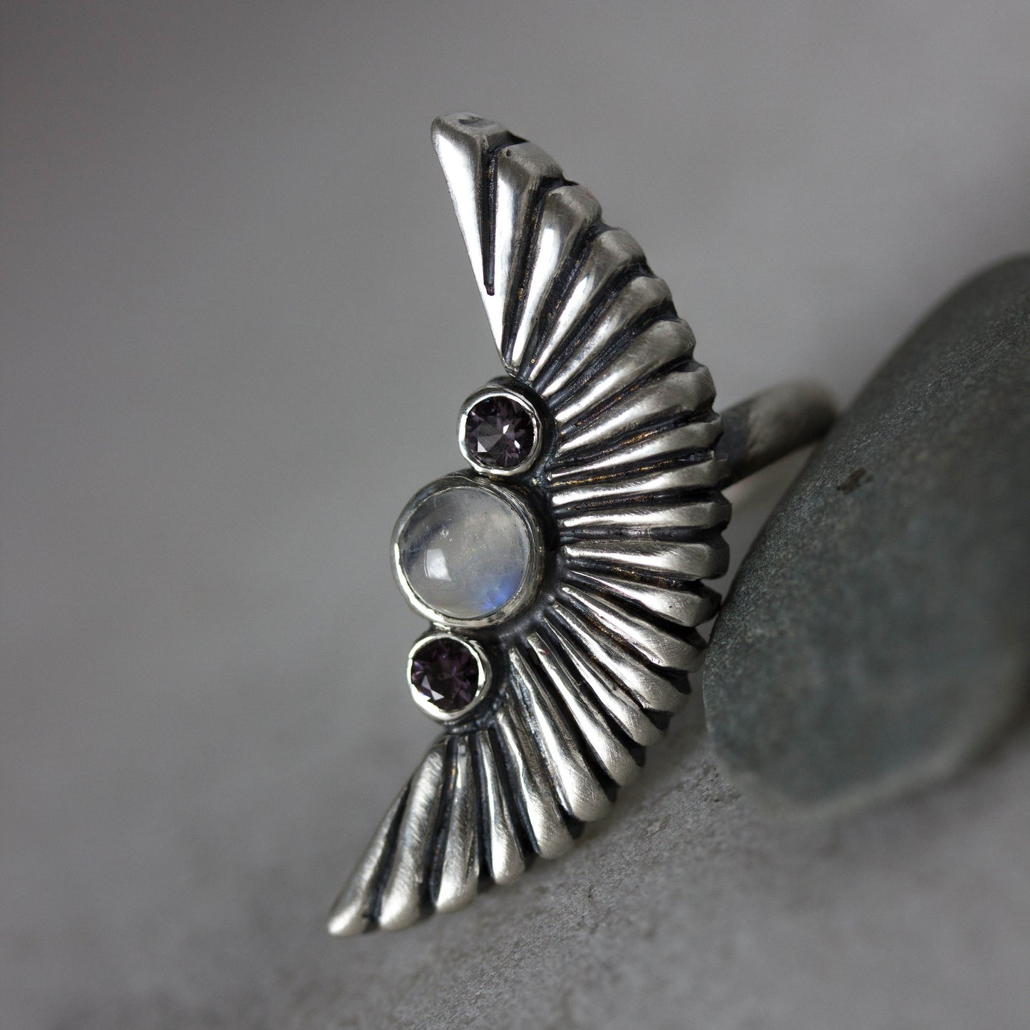 A handmade Silver Wing Statement Ring featuring a Rainbow Moonstone and Garnet Stone from Cassin Jewelry.