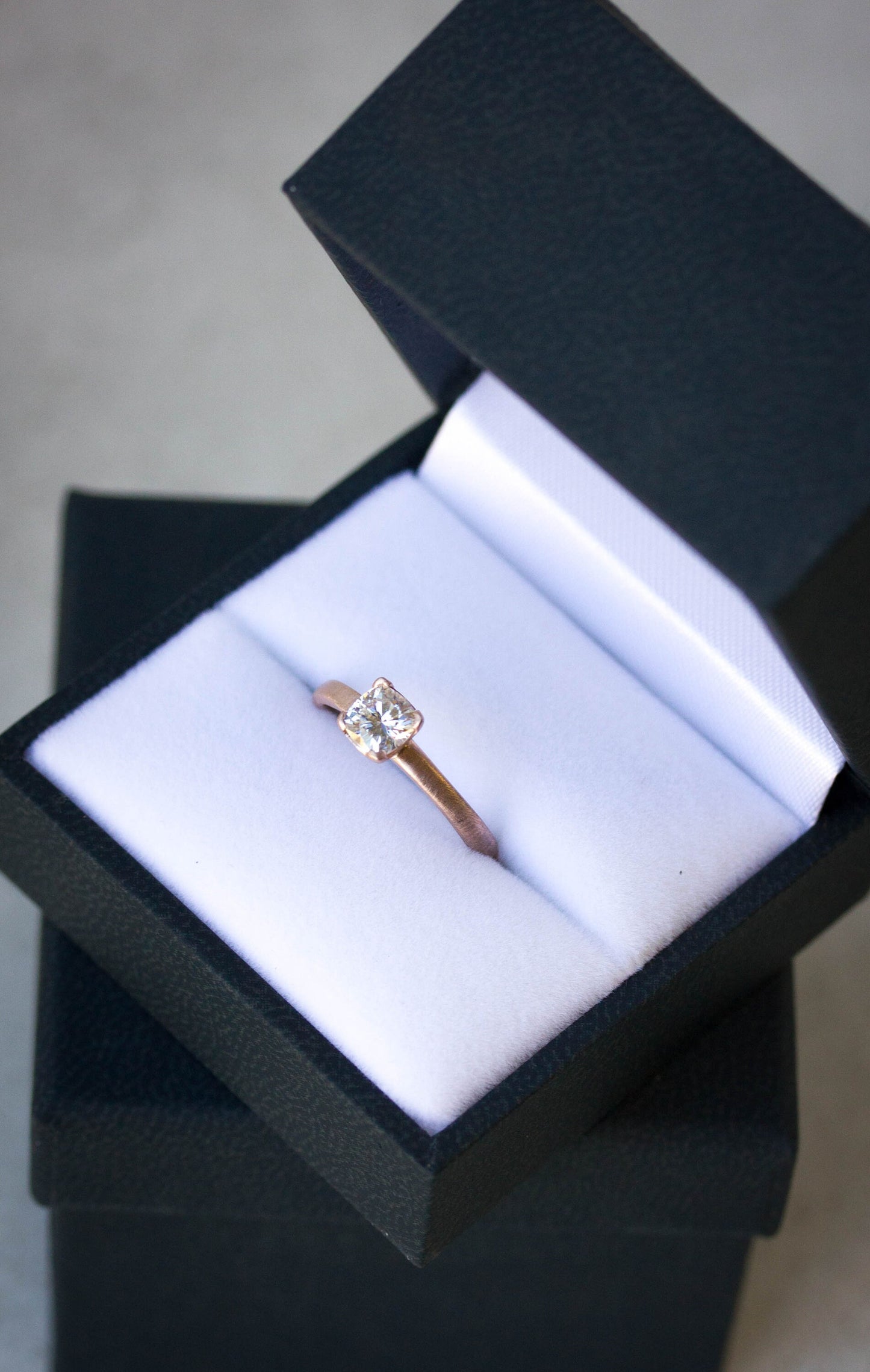 A Handmade White Topaz Engagement Ring by Cassin Jewelry in a black box.
