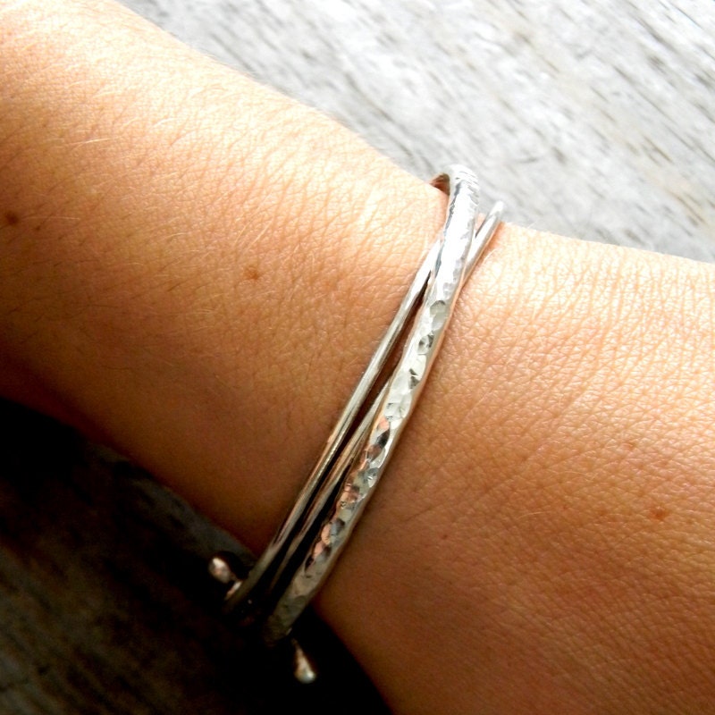 A woman's wrist with a Handmade Hammered Sterling Silver Boho Cuff Bracelet by Cassin Jewelry.