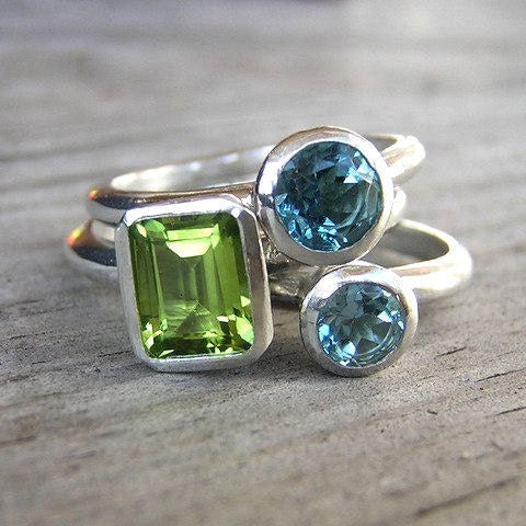 A pair of Cassin Jewelry handmade Peridot and Swiss Blue Topaz Gemstones Stacking Rings in Sterling Silver.