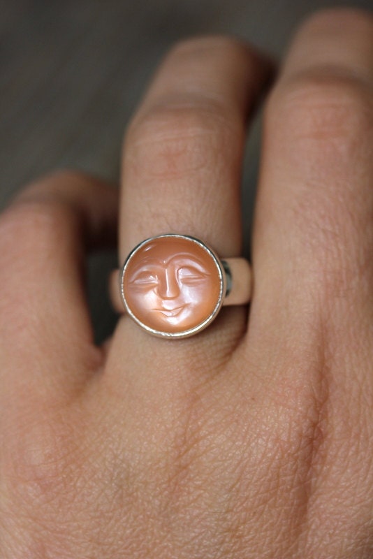 A person wearing a handmade Peach Moonstone Ring.