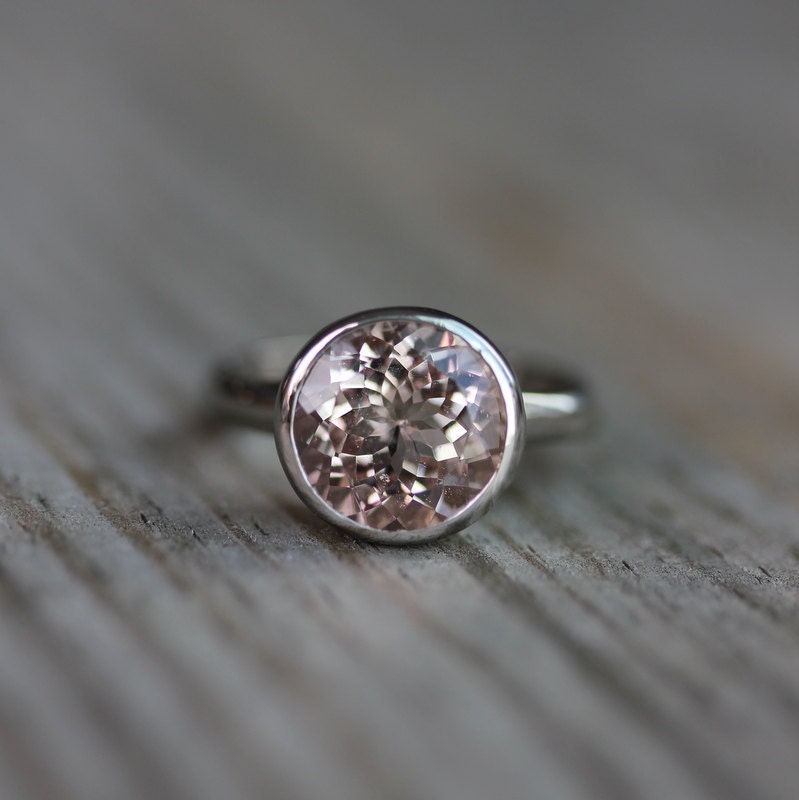 Handmade Round Morganite Ring in White Gold on a wooden table.