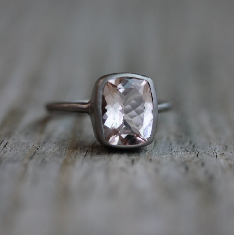 A handmade Morganite Ring in Palladium White Gold showcased on a wooden table.