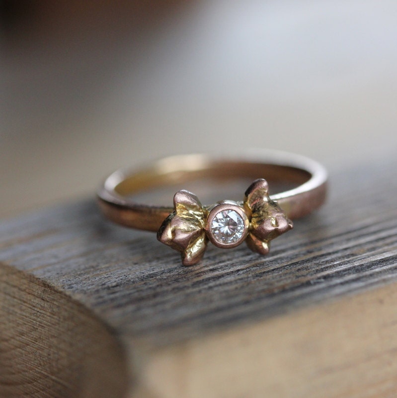 A handmade Moissanite Flower Bud Ring with a diamond in the center by Cassin Jewelry.