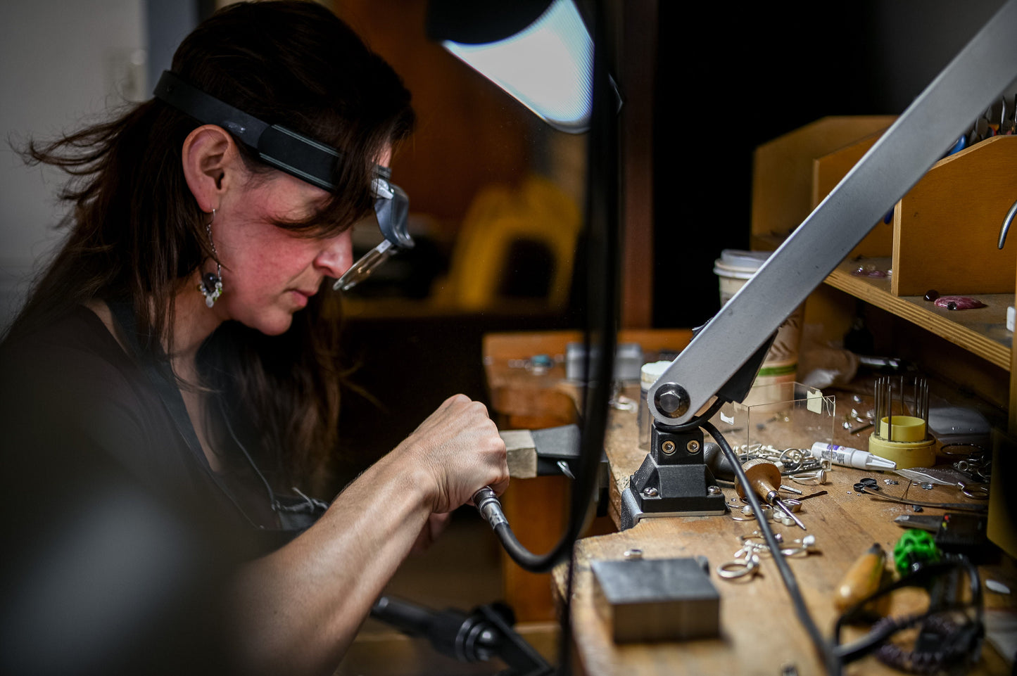 A woman is handcrafting a Round Forever One Moissanite Engagement Ring for Cassin Jewelry.