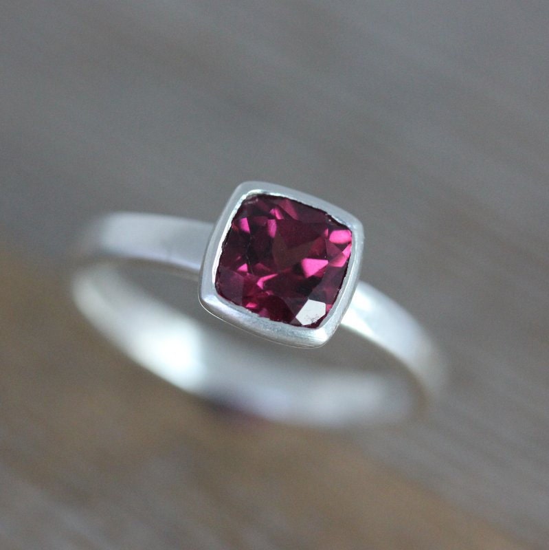 A Handmade Pink Garnet Ring featuring a pink sapphire center by Cassin Jewelry.