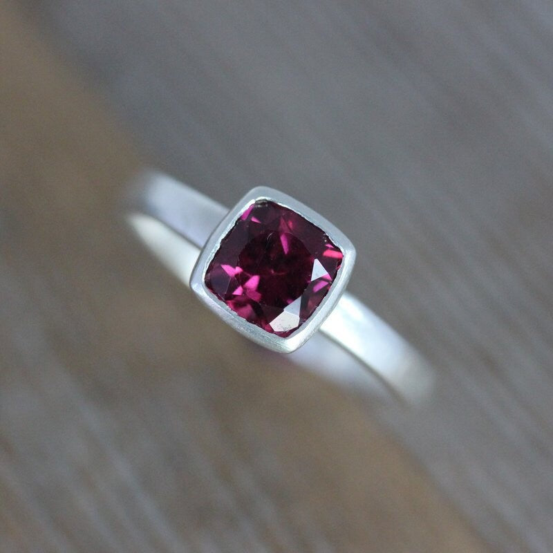 A handmade Pink Garnet Ring with a pink sapphire in the center by Cassin Jewelry.