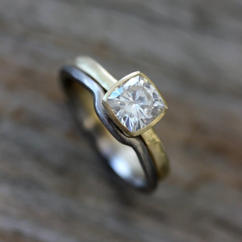 A handmade Moissanite Engagement Ring and Wedding Band Set with a cushion cut diamond by Cassin Jewelry.