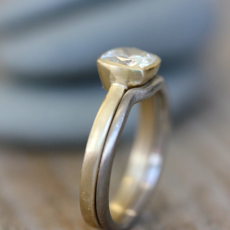 A Handmade Moissanite Engagement Ring and Wedding Band Set with a diamond in the middle.