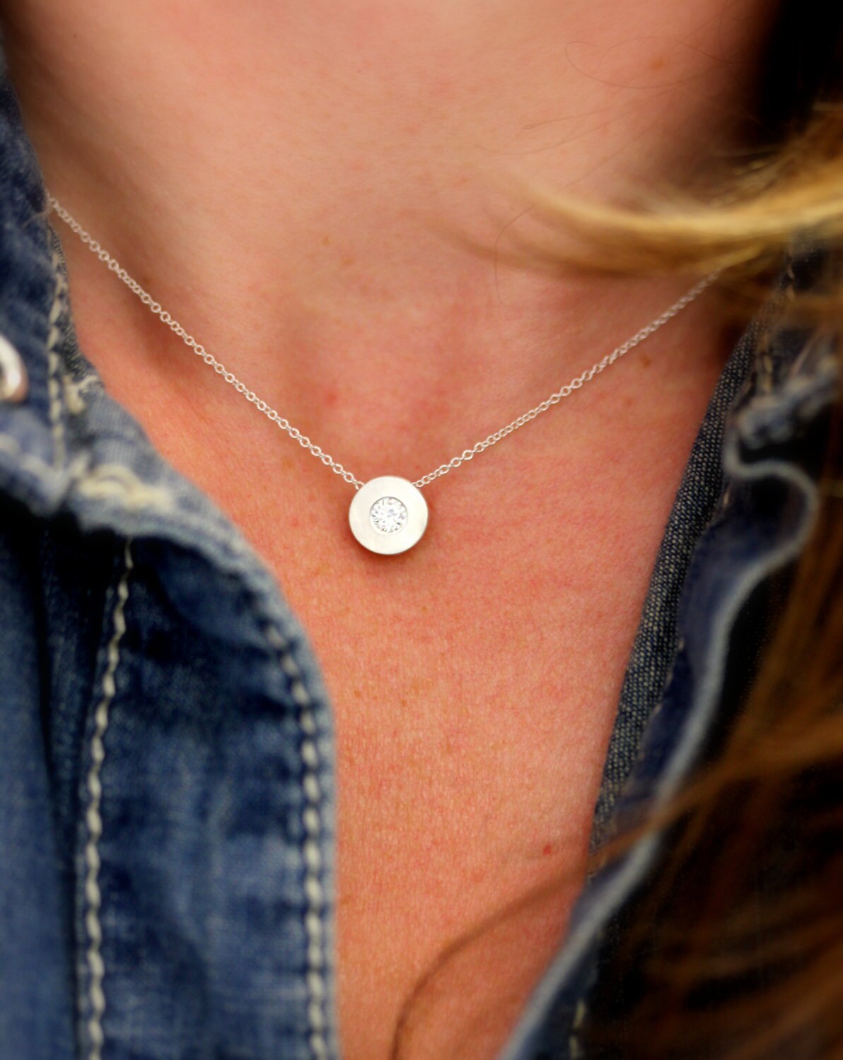 A woman wearing a handmade Moissanite necklace.